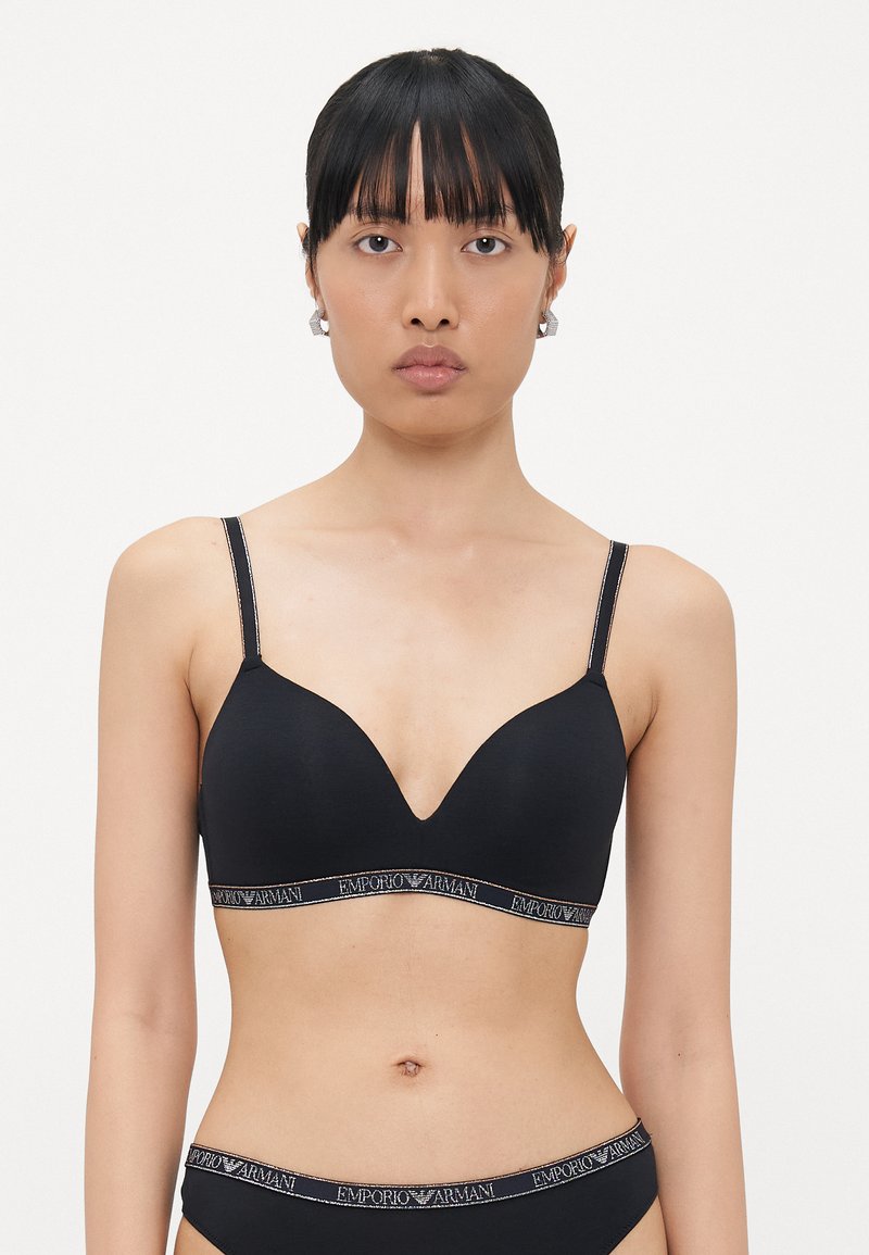 Zwarte draadloze beha met een diepe halslijn, dunne verstelbare banden en een gemarkeerde elastische band met "Emporio Armani" in contrasterende kleuren.