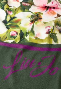 Floral patterned fabric with green background, featuring pink and white flowers. Includes a prominent purple logo, "Lin Jo". Soft texture.