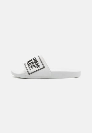 Slide sandal with a white synthetic upper featuring a black graphic design. Flat sole with a textured surface for grip. Open-toe style.