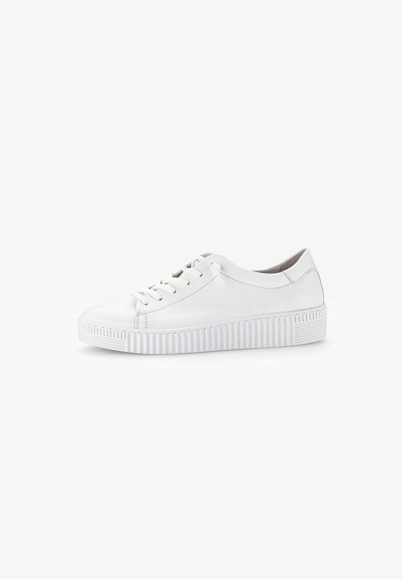 White leather sneakers with round toe, flat lace-up design, and textured rubber outsole featuring vertical grooves. Minimalist style.