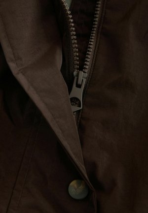 Brown jacket featuring a zippered closure and a button detail. Fabric appears smooth with a subtle sheen. Zipper and button are dark gray and green.