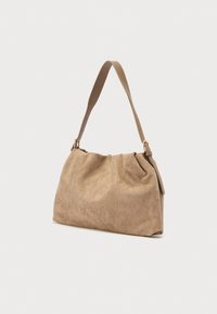 Μπεζ τσάντα ώμου από σουέτ με απαλό, υφασμένο φινίρισμα, διαθέτει έναν ιμάντα και λεπτομέρειες σε χρυσούς τόνους. Καμπύλο σχήμα.