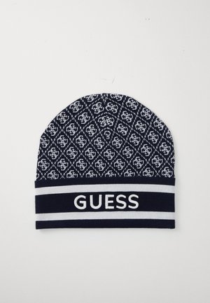 Strikket lue i marineblått med hvitt geometrisk mønster, med en hvit "GUESS"-logo på en kontrasterende stripet band.