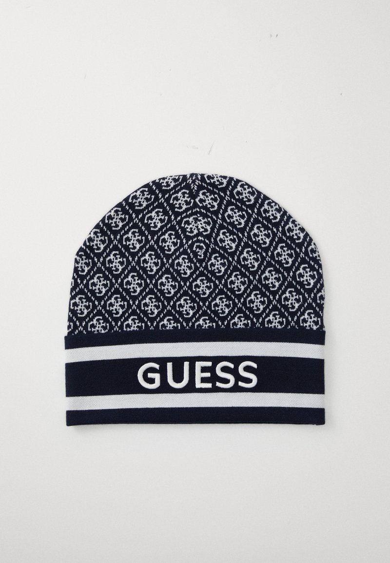 Strikket lue i marineblått med hvitt geometrisk mønster, med en hvit "GUESS"-logo på en kontrasterende stripet band.