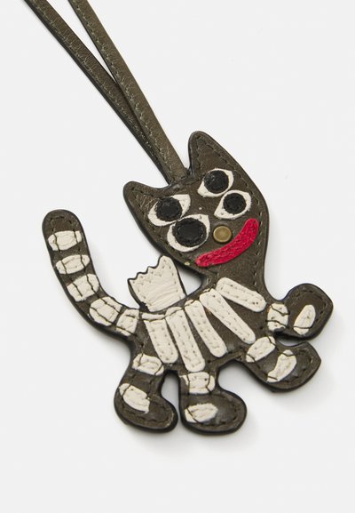 Leather cat-shaped accessory in black and white, featuring large eyes, a red mouth, and detailed stitching. It has a loop for attachment.