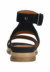 Zwarte suède sandaal met een open achterkant, voorzien van een gespband en een gestapelde lichtbruine zool. Ondersteuning met een minimalistisch strappy ontwerp.