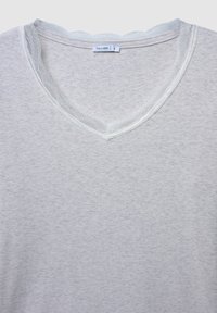 T-shirt grigio chiaro a costine con collo scalloppato, caratterizzato da un delicato bordo in pizzo bianco. Tessuto morbido con una vestibilità rilassata. Etichetta del marchio visibile.