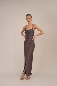 Rochie mulată, fără mâneci, dintr-un material strălucitor de culoare burgundă închisă, având o fente până la coapsă și bretele subțiri. Accente aurii la încălțăminte.