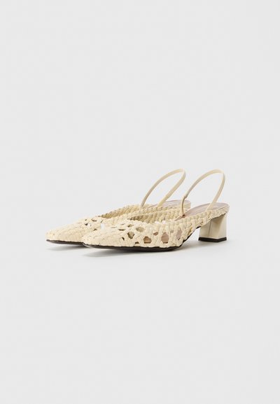 Zapatos de tacón slingback tejidos color crema con puntera afilada, tacón bajo y diseño recortado. Fabricados en material sintético con una textura suave.
