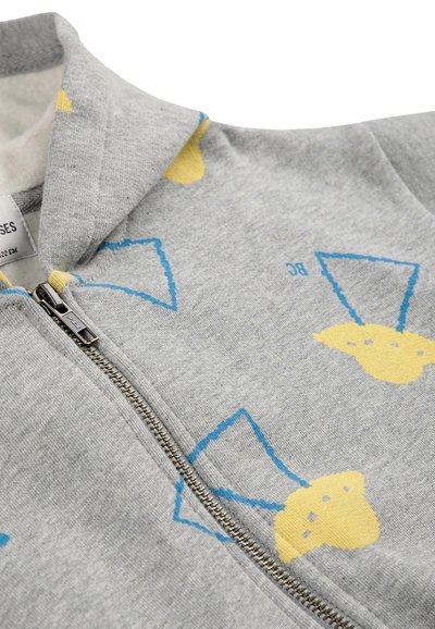 Sweat à capuche gris zippé avec un motif subtil de formes jaunes délimitées en bleu et une petite étiquette de vêtement visible à l'intérieur du col.