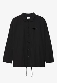 Black long-sleeve shirt with a relaxed fit, featuring a button-up closure and a small oval logo accent on the left chest.