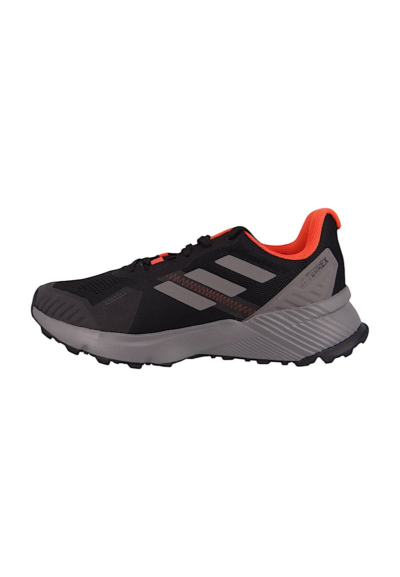 Chaussure de sport noire avec des accents gris et des détails orange vif. Présente un dessus en mesh, une semelle rembourrée et une semelle extérieure en caoutchouc texturé pour l'adhérence.