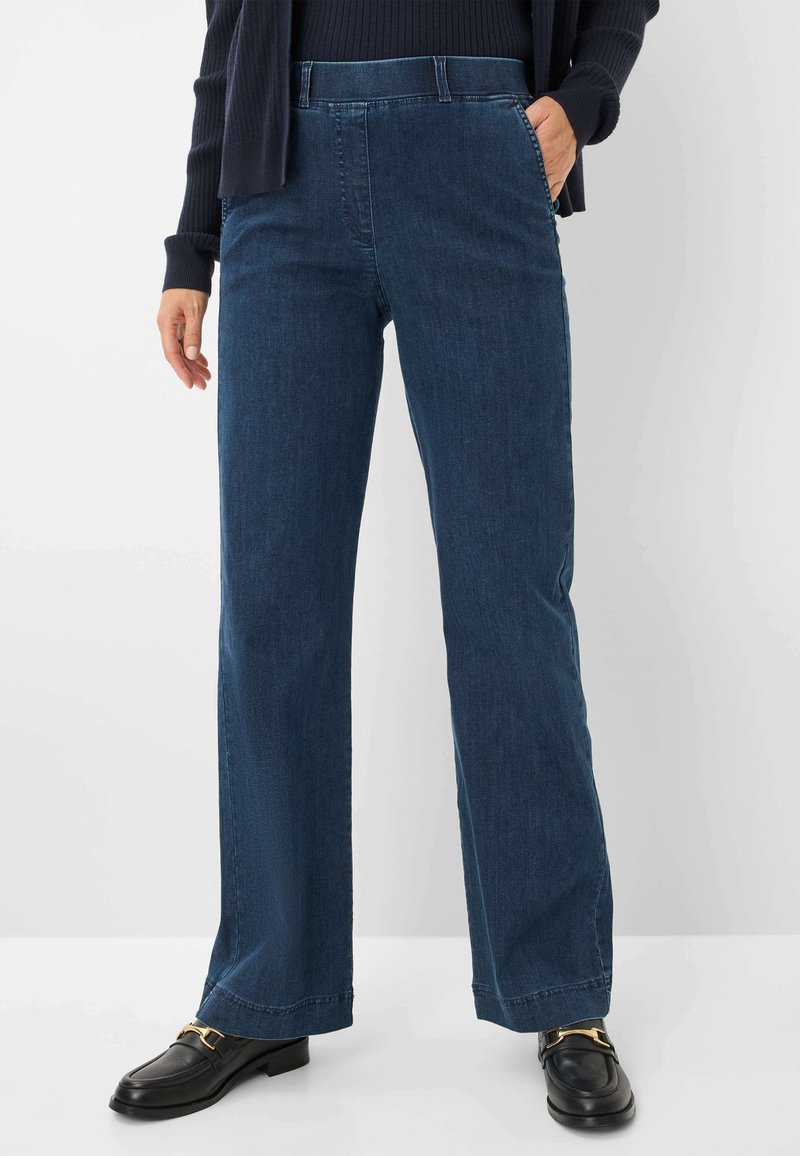 Blauwe denim broek met rechte pijpen en een middelhoge taille, voorzien van zakken en een nette, gepolijste afwerking. Gegdragen met zwarte instappers.