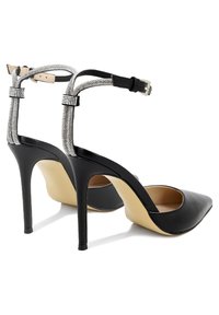 Scarpe con tacco alto nere con finitura in pelle liscia, punta affusolata e cinturini metallici con strass alla caviglia.