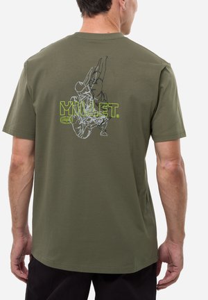 Homme portant un t-shirt vert olive avec un graphisme de corde d'escalade et le texte "MILLET" en vert vif dans le dos.