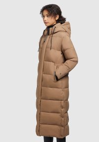 Manteau long rembourré marron avec une capuche, présentant des poches latérales, un matelassage horizontal et des cordons de serrage ajustables au niveau du col.
