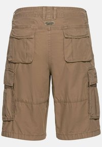 Khaki cargo shorts with multiple flap pockets, belt loops, and a label reading "Made for daily adventures since 1977" on the back waistband.