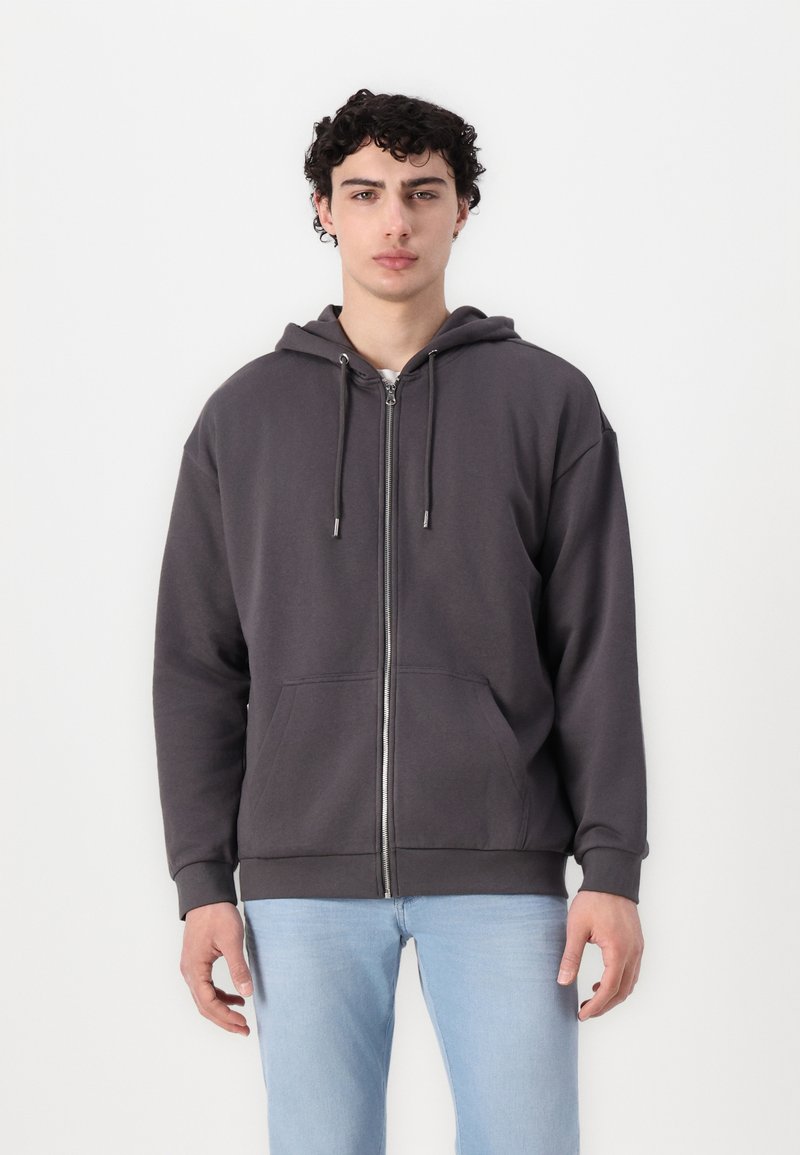 Zip-up hette i mørkegrå, laget av myk stoff. Har snorhette, frontlommer og ribbede mansjetter ved ermer og nederkant.