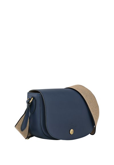 Navyleder Umhängetasche mit einem strukturierten, tanfarbenen Gurt. Sie verfügt über einen Klappverschluss, goldene Beschläge und ein eingeprägtes Logo auf der Vorderseite.