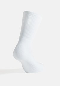 Calzino bianco in cotone, texture a costine, lunghezza a metà polpaccio, punta e tallone rinforzati, finitura liscia, design minimale senza motivi o loghi.