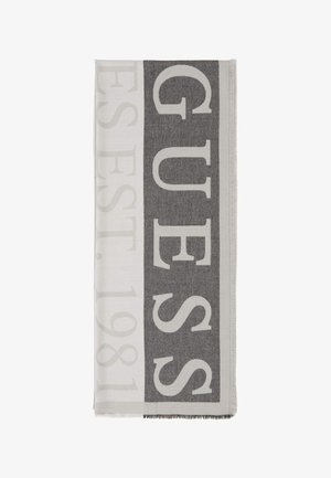 Écharpe tissée grise et blanche présentant un grand texte "GUESS" et "EST. 1981," avec des bords à franges et une texture douce.