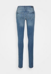 Jeans skinny de denim azul com um cós médio, apresentando um acabamento liso, dois bolsos traseiros e detalhes de costura mínimos.
