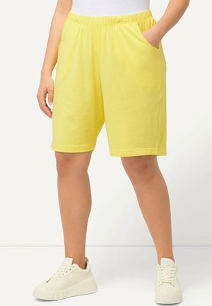 Gelbe Baumwollshorts mit einem elastischen Bund und Seitentaschen. Das Design hat einen knielangen Schnitt und eine weiche Textur.
