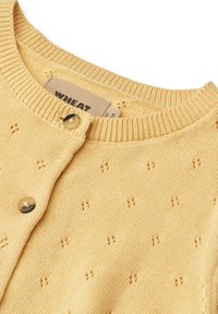 Yellow knitted cardigan with a round neck, featuring small textured patterns and button closure. Tag reads "WHEAT." Smooth texture.