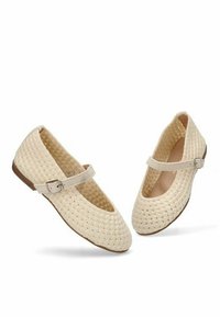 Bailarinas trenzadas beige con una correa estilo Mary Jane, suela plana y superficie texturizada. El detalle de hebilla en la correa añade un acento funcional.