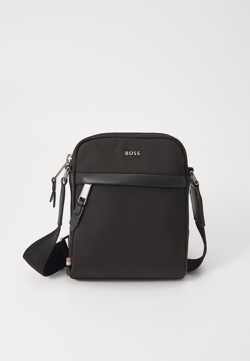 Borsa a tracolla nera con un tessuto texture, logo sul davanti, chiusura con zip e tracolla regolabile. Presenta un bordo in pelle liscia.