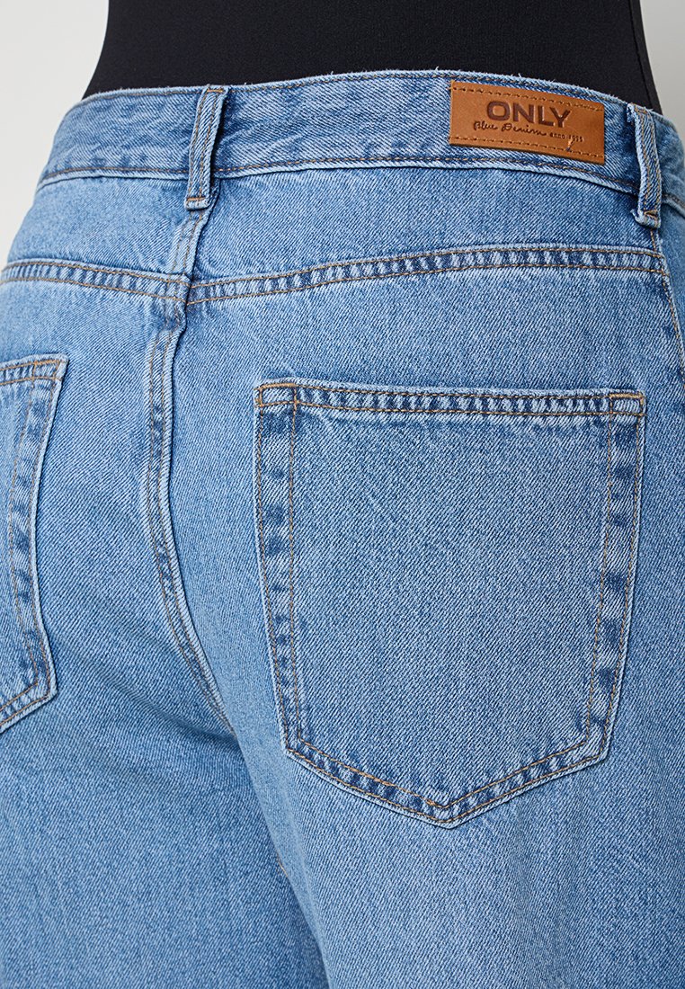 Jasnoniebieskie dżinsy z średnim stanem, z brązowym skórzanym logo z tyłu i dwiema tylnymi kieszeniami z subtelnym przeszyciem.