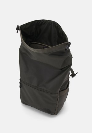 Sac à dos imperméable vert foncé avec un design à rabat. Dispose de bretelles réglables, d'une poche zippée sur le devant et de détails de logo subtils.