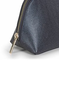 Navyblauwe cosmetica pouch van textuurmateriaal, met een gouden rits en gladde accenten. Driehoekige vorm met een vlakke basis voor stabiliteit.