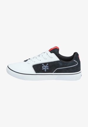 White athletic shoe with black suede accents, gray logo, and red heel tab. Features a classic lace-up design and textured rubber sole.