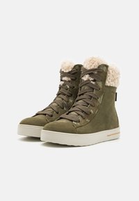Zapatillas altas de color verde oliva con upper texturizado, forro de crema suave y suela de goma beige. Presentan cordones y marca lateral.