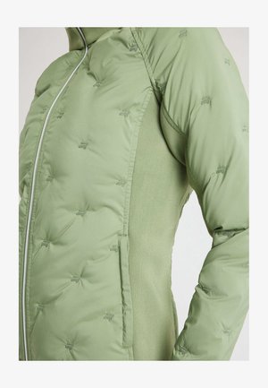 Lichtgroene gewatteerde jas met doorgestikte kleine logo's, centrale rits en gebreide zijpanelen, getoond van het midden van de romp tot de bovenarm.