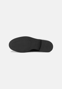Suola in pelle nera con una texture liscia, forma arrotondata e un motivo a rilievo minimo. Presenta un logo del marchio impresso e dettagli sulla taglia.