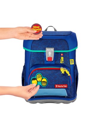 Blue children's backpack with textured surface, green and red accents, features a front pocket, custom patches, and a sturdy handle.