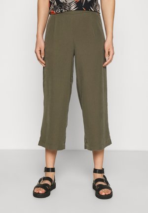 Pantaloni cropped in tessuto verde oliva, caratterizzati da un design a gamba dritta e orlo semplice. Abbinati a sandali neri con cinturini.