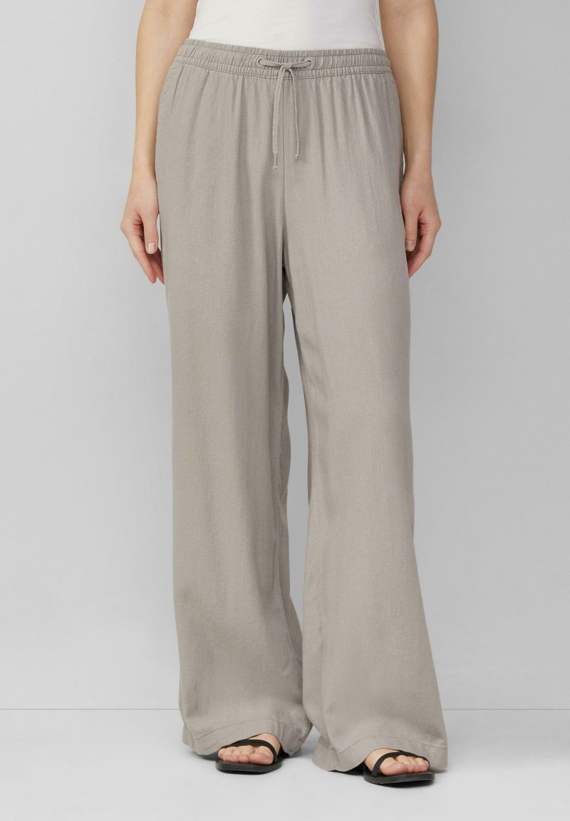 Lichtgrijze, wijde broek met een elastische tailleband en een koord. Gemaakt van een zachte, lichte stof. Rechte snit.