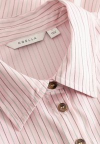 Růžová košile s límečkem s tenkými vertikálními pruhy v černé a tyrkysové barvě, s hnědými knoflíky a látkovou štítkem s nápisem "Noella."