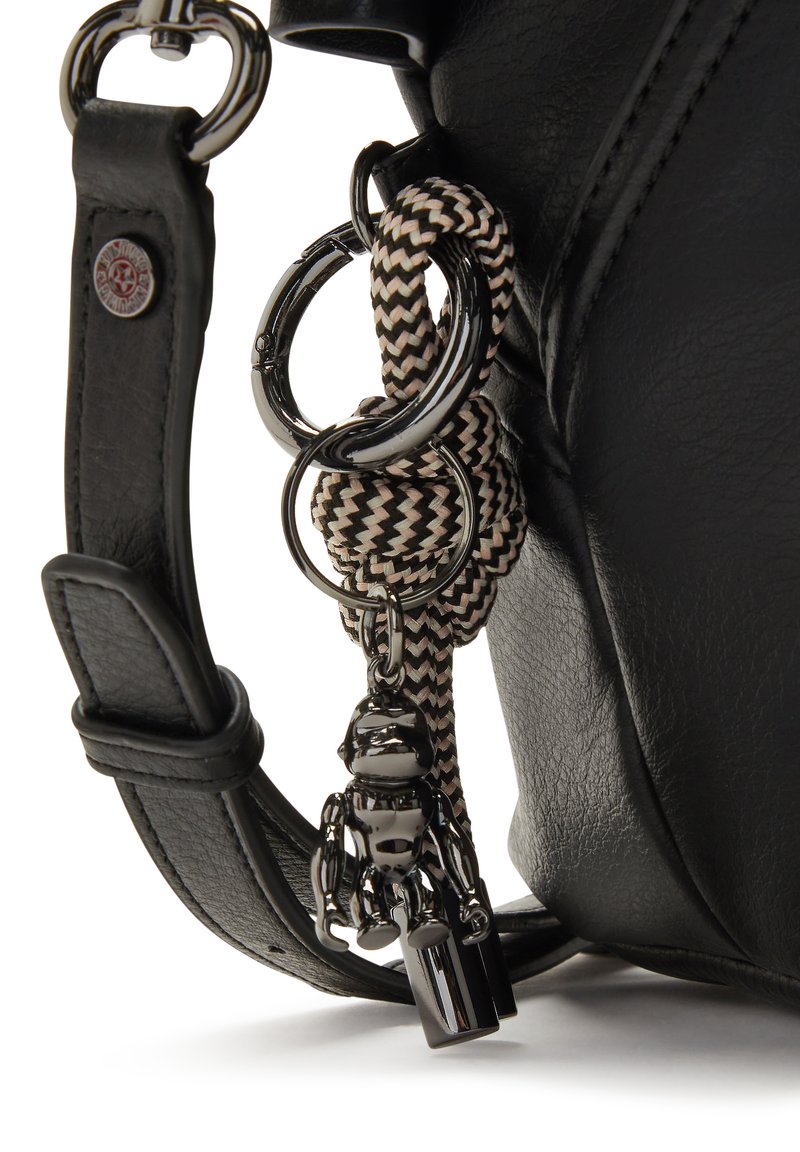 Correa de bolso de cuero negro con anillos plateados, llavero de cordón trenzado en blanco y negro que sostiene un pequeño charm de robot brillante y una etiqueta.