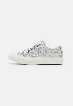 Niskie sneakersy całkowicie pokryte srebrnym brokatem, biała gumowa podeszwa oraz białe sznurówki z czarnym wzorem napisu "LOVE".