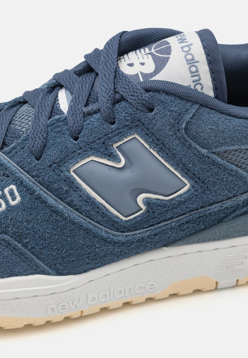 Sneaker blu in suede con upper testurizzato, chiusura con lacci e un accento bianco del logo. Suola in gomma di colore beige chiaro, per garantire aderenza.