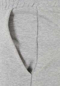 Lichtgrijze katoenen joggers met een diepe zijzakopening en een elastische tailleband voor comfort en gemak. Zachte textuur, casual ontwerp.