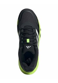 Chaussure de sport noire avec une tige texturée, ornée d'accents vert fluo et de trois bandes blanches. Les lacets sont positionnés au centre de la chaussure.