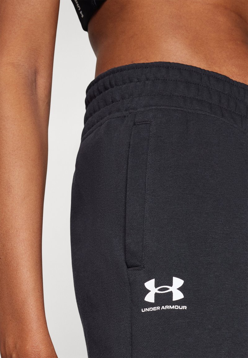 Černé sportovní teplákové kalhoty s elastickým pasem, bočními kapsami a bílým logem Under Armour na dolní části nohy.