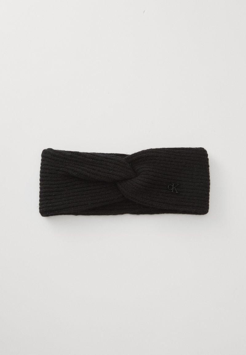 Faixa de cabelo tricotada preta com um design torcido, textura canelada e um pequeno logotipo em destaque. Material macio adequado para climas mais frios.