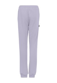 Ljuslavendelfärgade sweatpants med elastisk midja och avslutade anklar. Tillverkade av ett mjukt material, med en liten logotagg på sidan.
