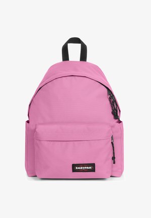 Pink nylon backpack with a rounded shape, front pocket, black zipper, adjustable straps, and a top handle. Logo visible on front.